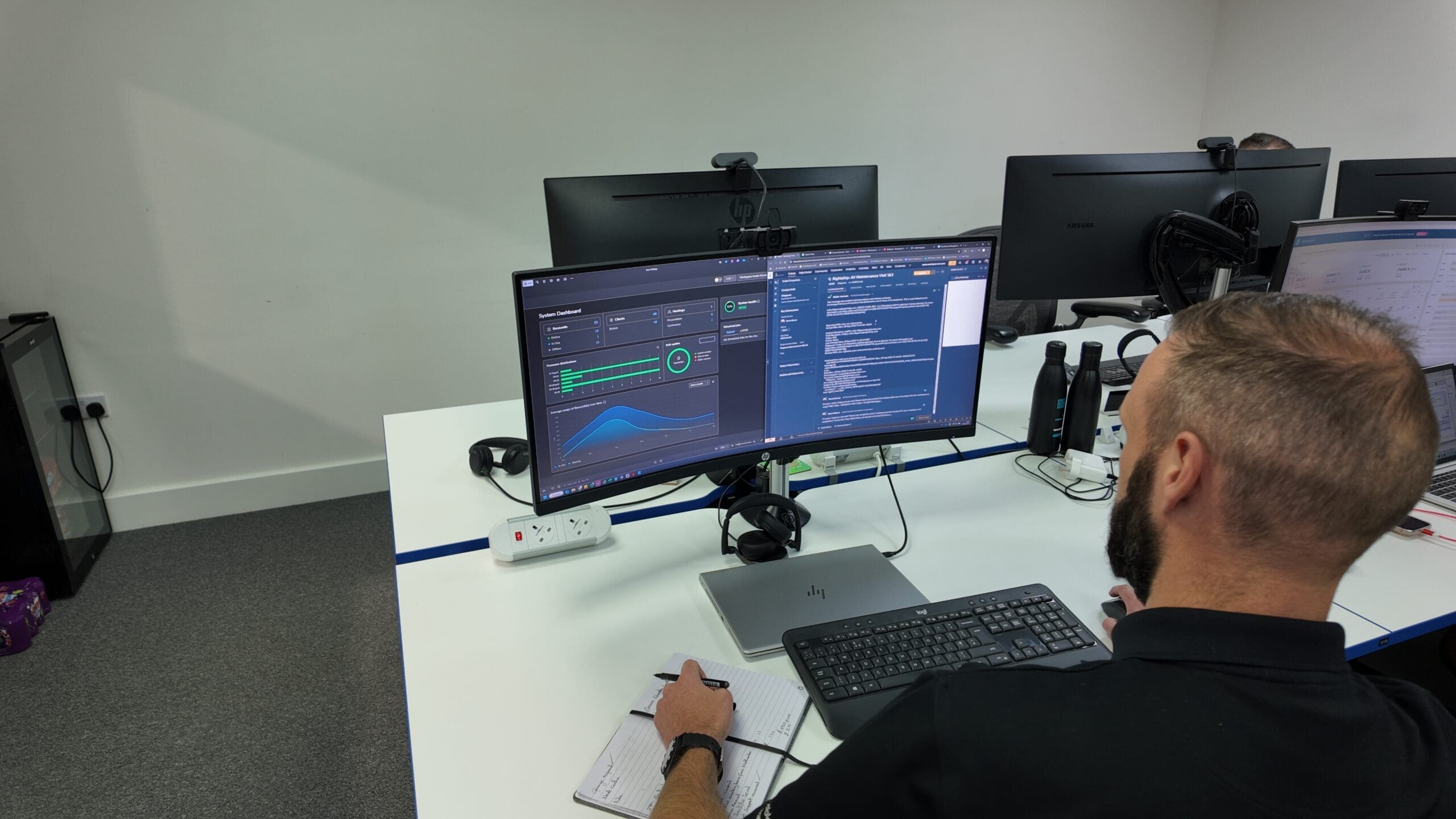 man in black shirt sitting in front of monitor displaying graphs